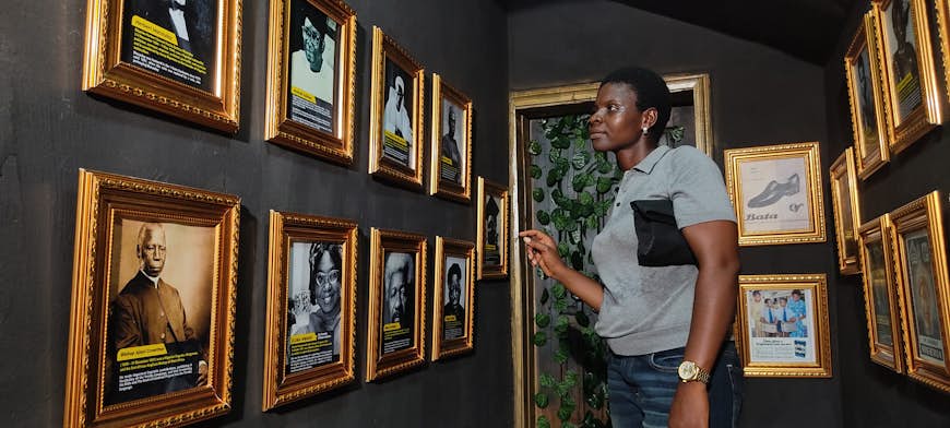 Une femme examine des photographies encadrées au Museum of Vintage Africana