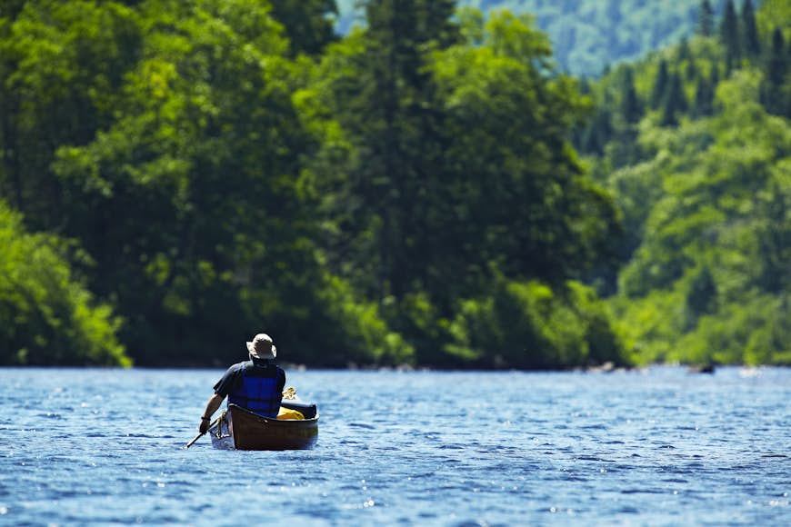 Man paddling canoe on the river in Parc National du Jacques-Cartier Park, Canada