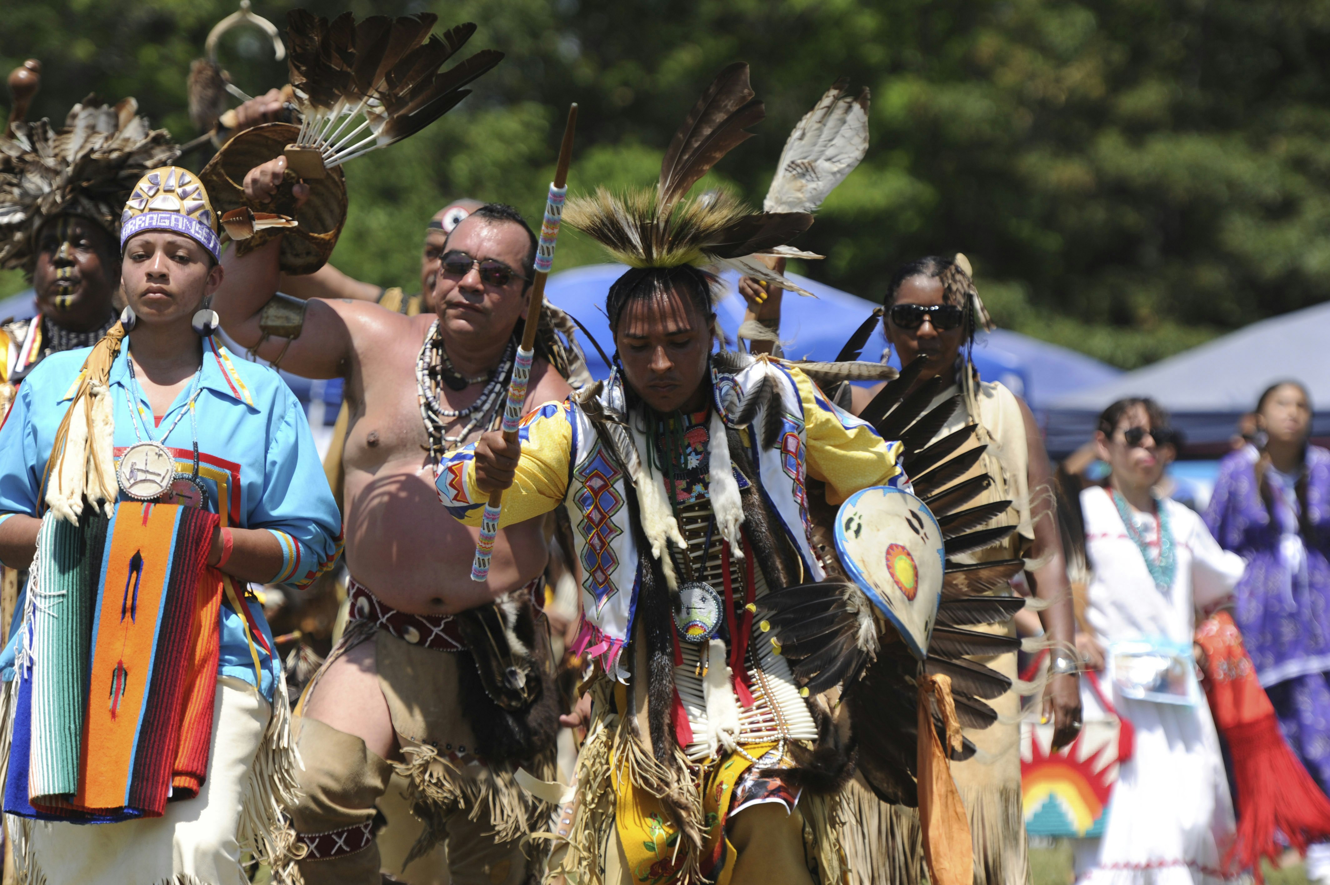 Members of the Mashpee Wampanoag enter the arena during the Grand Ceremony at Barnstable County Fairgrounds in East Falmouth.