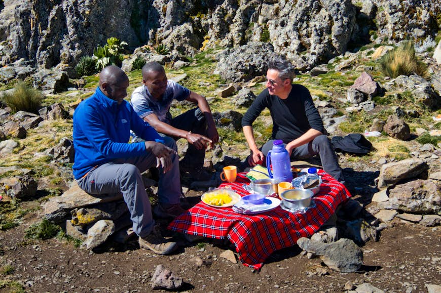 Writer Peter Elia and guides, Benson and Samir pause for breakfast on Mt Kenya