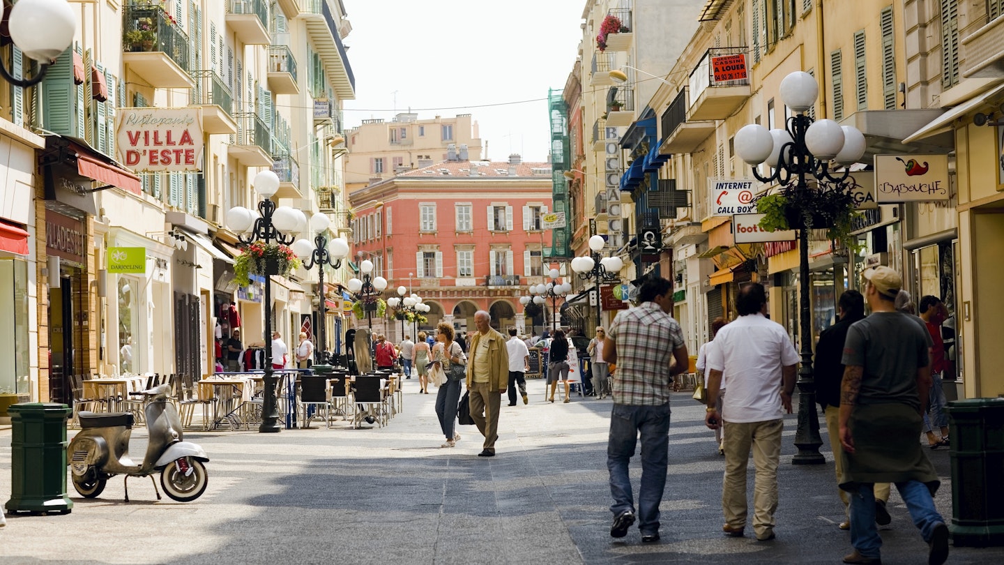 A busy street in Nice, France with people browsing street stalls 