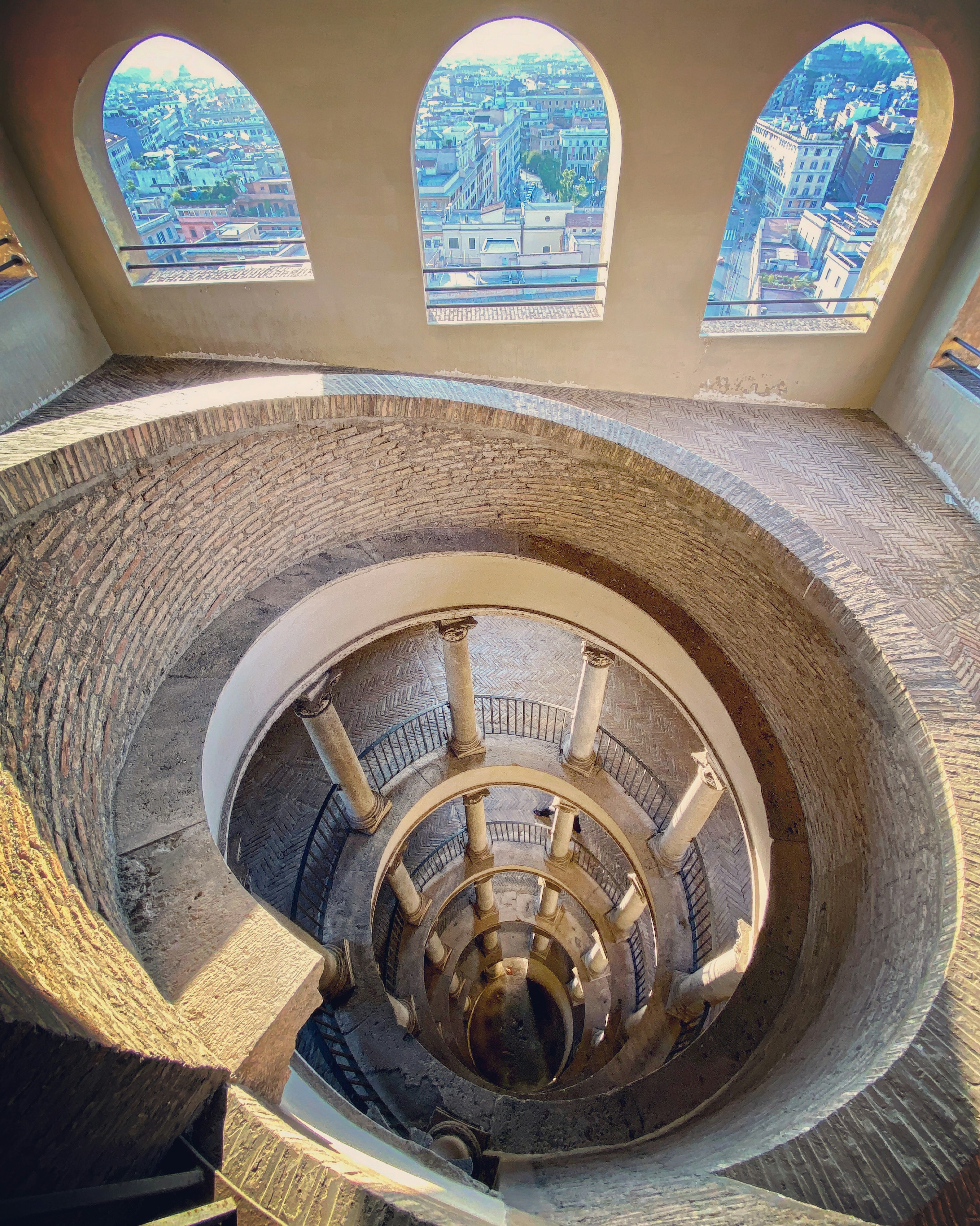 A spiral staircase winds down through the Vatican Museums.