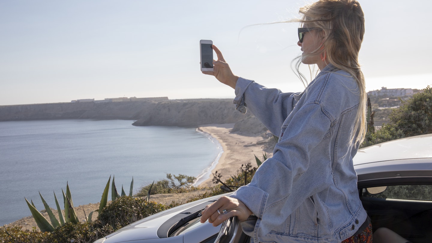A driver pauses to take a photo of the coast on the Algarve