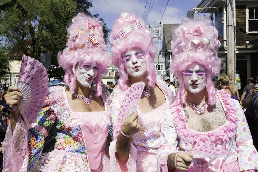 Drag queens in pink wigs walking in the annual Provincetown Carnival Parade in Provincetown. 