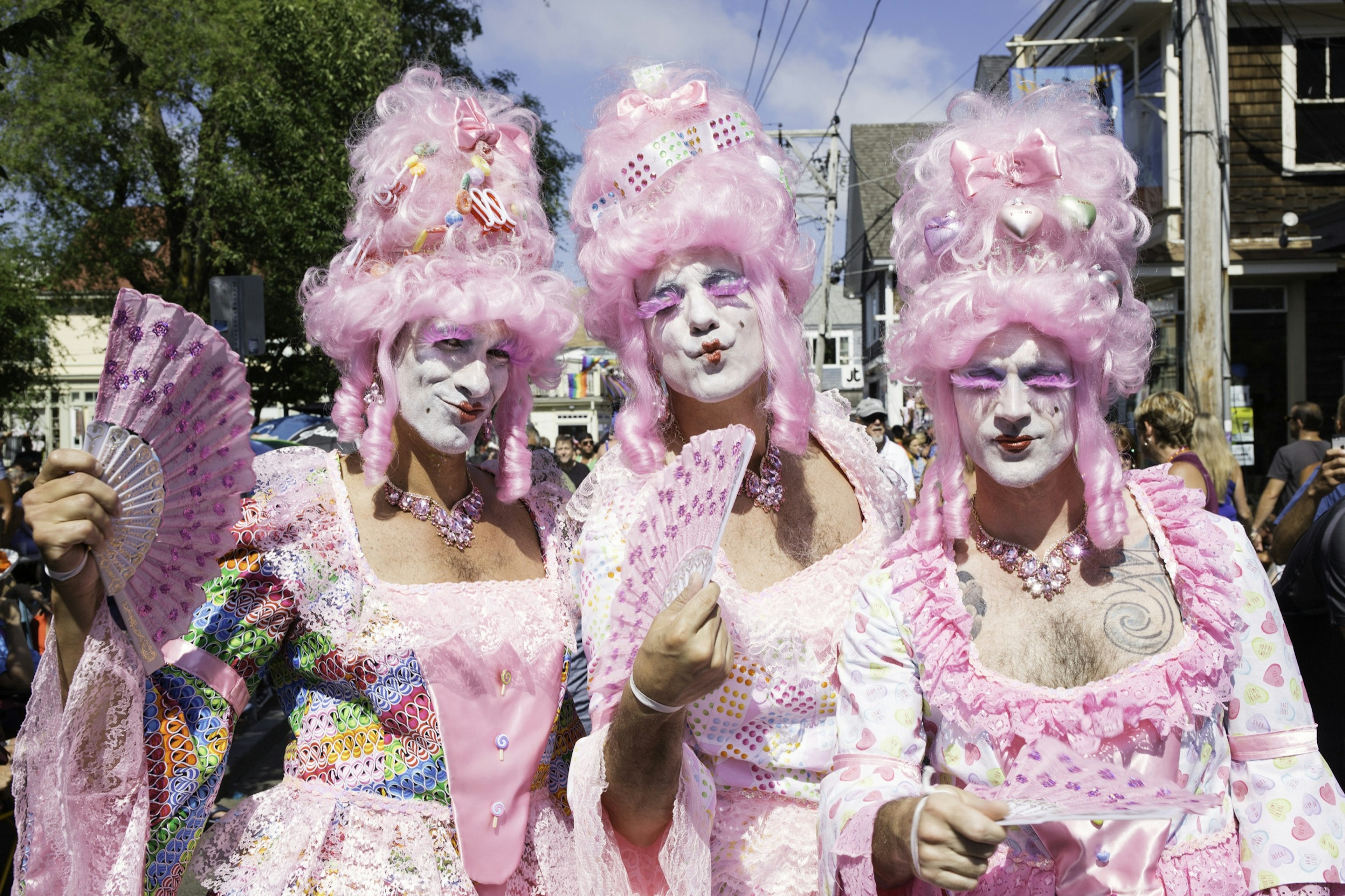 Drag queens in pink wigs walking in the annual Provincetown Carnival Parade in Provincetown.