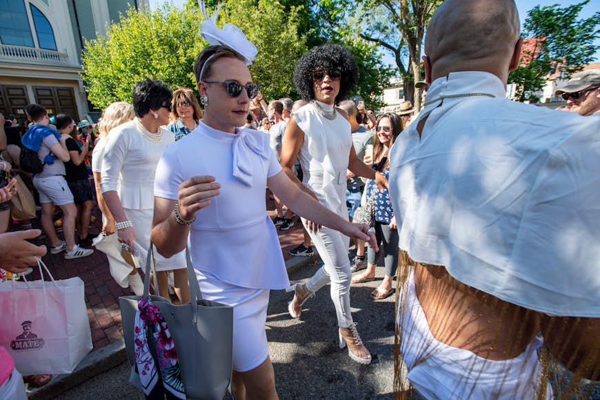 A group of people wearing fancy white outfits, attend a tea party in Provincetown.