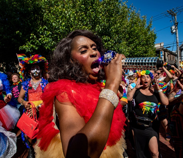Entertainer Qya Cristal holds a chrome microphone during performance at a Pride rally in Provincetown, Massachusetts. 