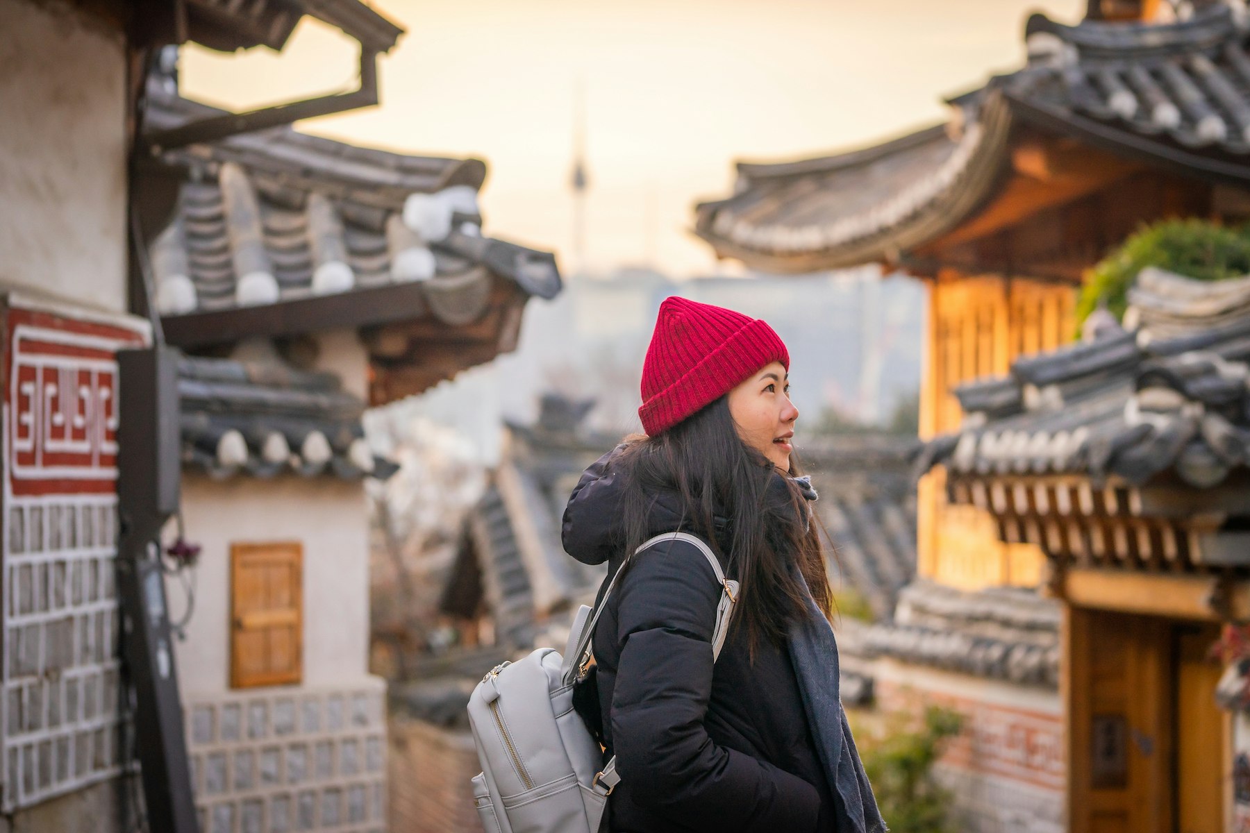Casual Portrait of Smiling Young Asian Tourist at Traditional Bukchon Hanok Village in Winter at Sunrise, Seoul, Korea; Shutterstock ID 1376673824; your: Brian Healy; gl: 65050; netsuite: Lonely Planet Online Editorial; full: Best neighborhoods in Seoul