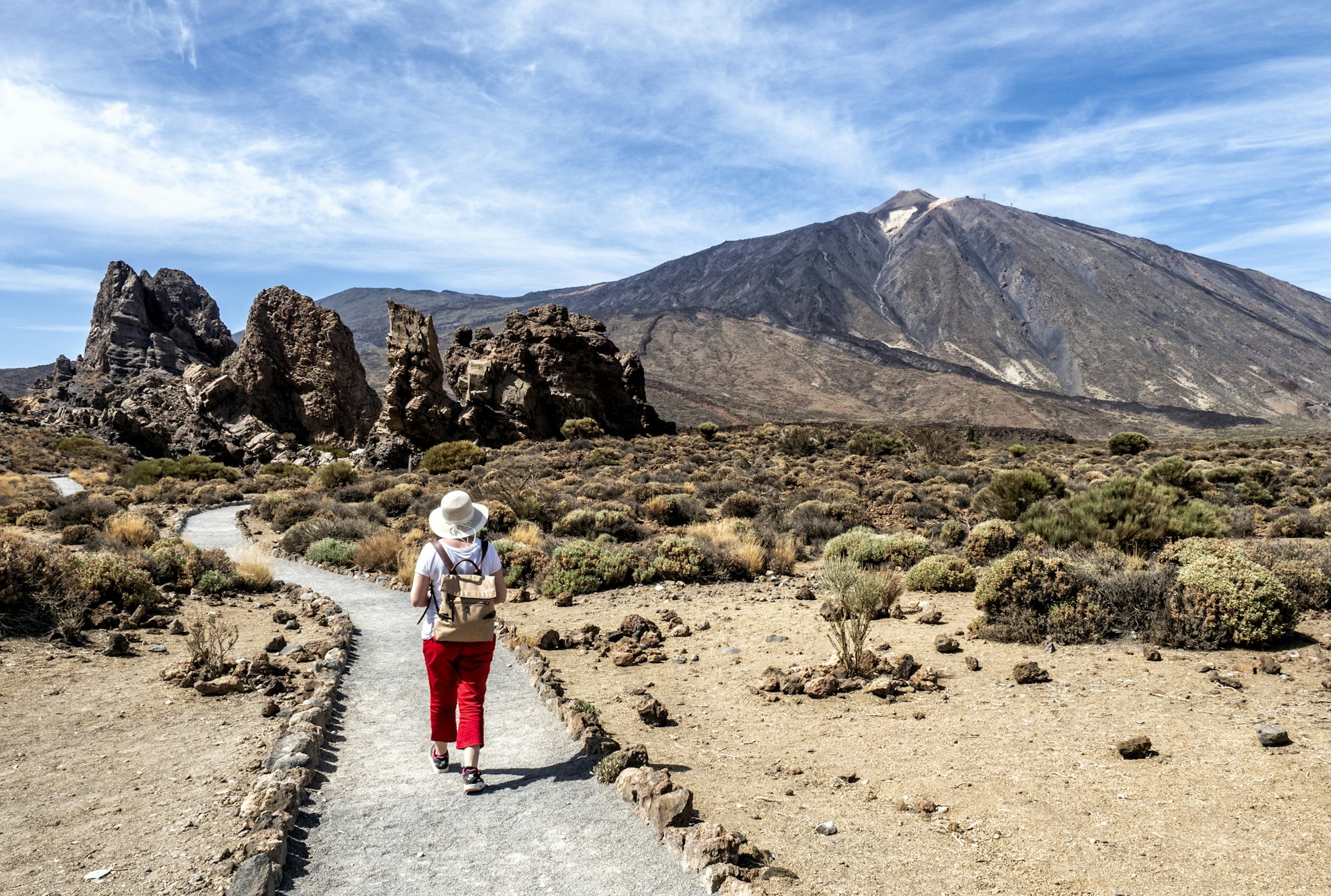 A woman hiking through a volcanic mountain landscape in Tenerife, Canary Islands
