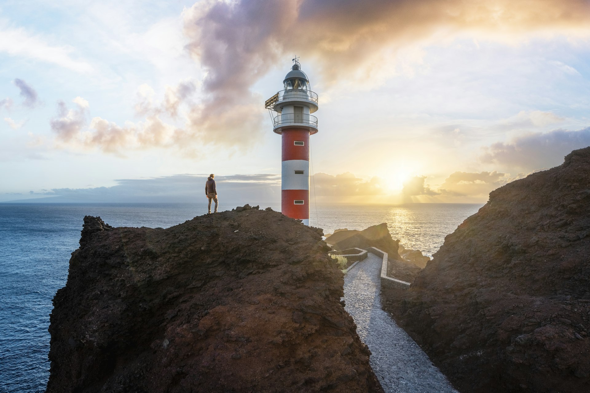 A hiker looks at the Punta de Teno lighthouse, Tenerife