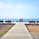 People relaxing in front of beach - stock photo
Santa Cruz,Tenerife, island of Spain - February 6, 2020: Playa de Las Americas. Disabled senior lady shooting with smartphone some seascapes. Other persons sitting on a park bench. man and woman, couple talking.