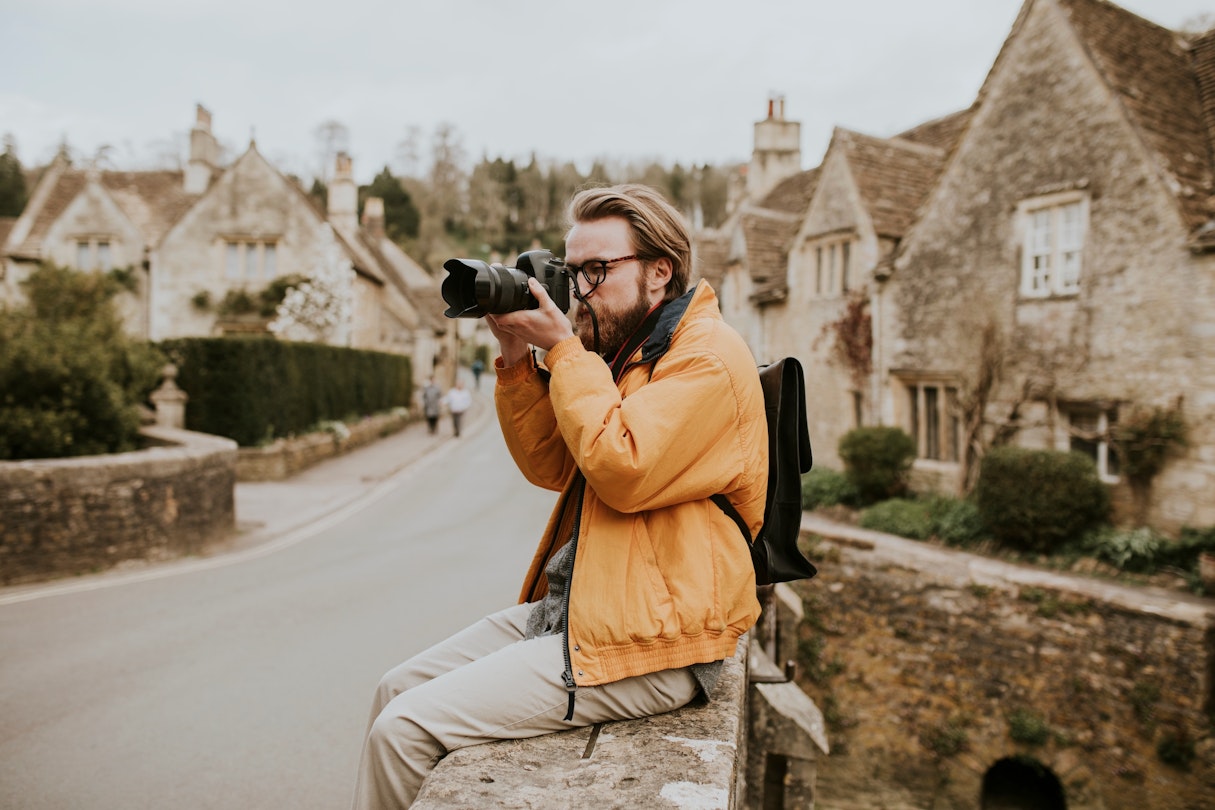 Photographer man taking photos in the village in Cotswolds, UK; Shutterstock ID 2039173658; your: Brian Healy; gl: 65050; netsuite: Lonely Planet Online Editorial; full: When to travel to the Cotswolds