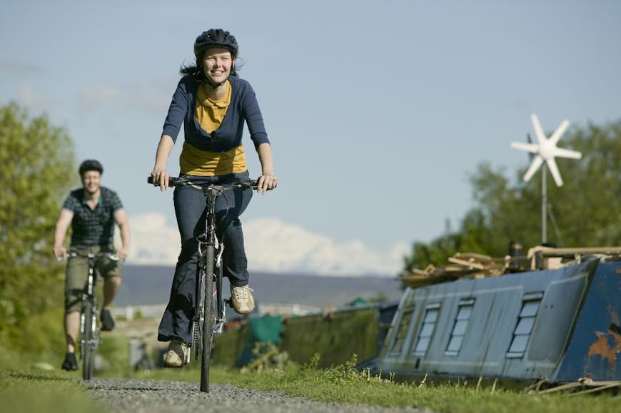 Couple cycling along canal towpath near Glasson Dock in Lancashire, England, United Kingdom