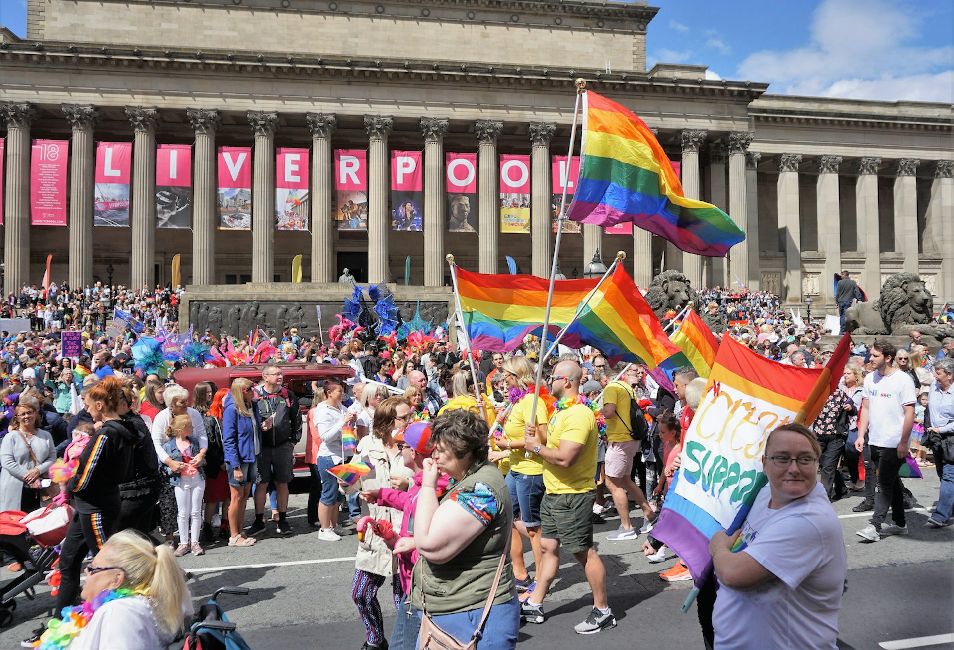Marchers wave rainbow flags in front of St George’s Hall during the Pride parade, Liverpool, England, United Kingdom