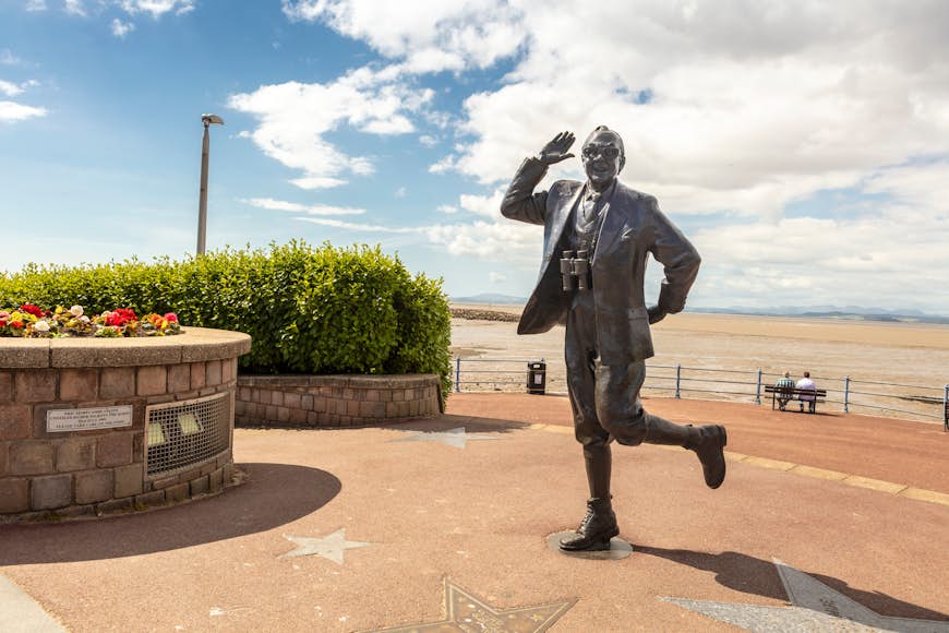 Bronze statue of famous English comedian Eric Morecambe on the seafront promenade of Morecambe, Lancashire, England, United Kingdom