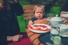 Mother and toddler enjoying cream tea in a garden the proper way with jam on top of the cream; Shutterstock ID 1099937564; your: Brian Healy; gl: 65050 ; netsuite: Lonely Planet Online Editorial; full: Dining in the Cotswolds