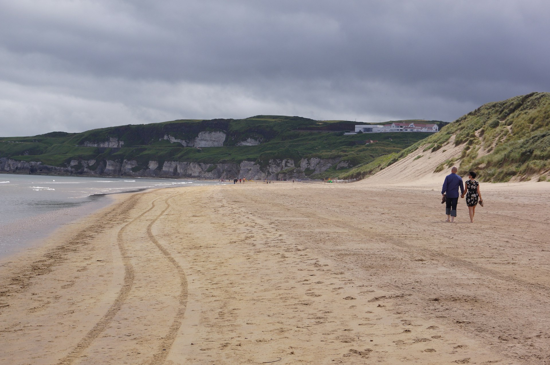 Two people walk on Whiterocks Beach, Portrush, County Antrim, Northern Ireland, United Kingdom