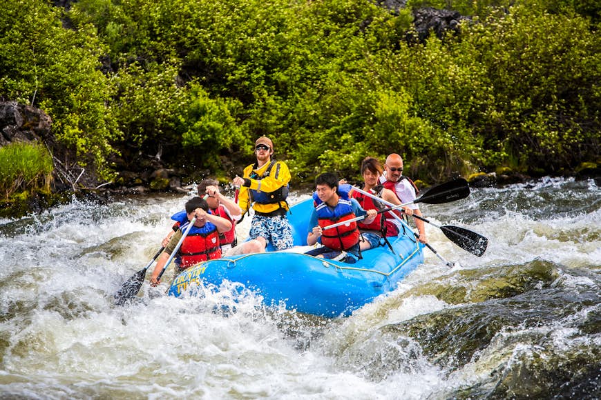 A group of people rafting in a rubber raft on the Deschutes River