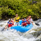 Bend, Oregon - 6/12/2009: group of people white water rafting in a rubber raft on the Deschutes River at Big Eddy rapid - a class 4 rapid - near Bend.
