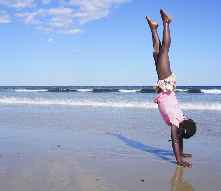 Girl doing a handstand on a Maine beach