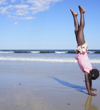 Girl doing a handstand on a Maine beach