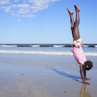 Girl doing a handstand on a Maine beach