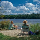 Pocono Lake, PA USA - April 6, 2021: Two Women Sitting by Pocono Lake to Cool Off From Summer Heat; Shutterstock ID 1950967123; your: Brian Healy; gl: 65050; netsuite: Lonely Planet Online Editorial; full: Best time to visit the Poconos