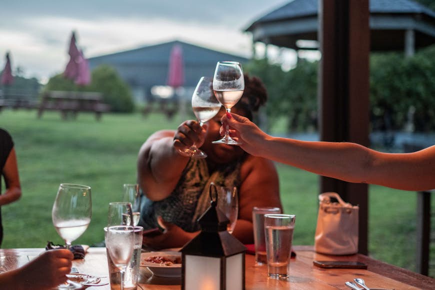 Les convives lèvent un toast dans la salle à manger extérieure de JOLO Winery & Vineyards