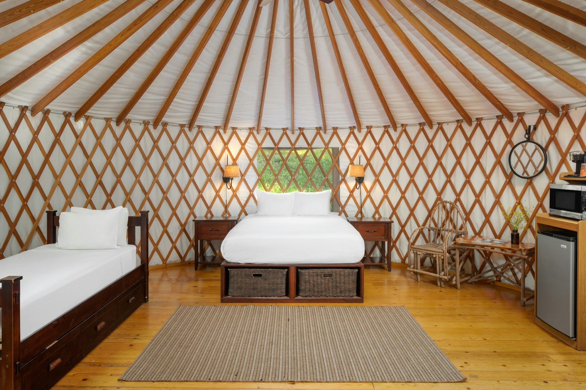 A bed with white sheets in a luxury yurt at El Capitan Canyon, Santa Barbara, California, USA
