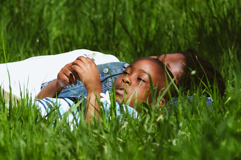 Mother and son lazing in a lush green field