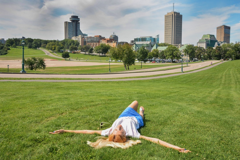 A girl lies on the grass in Parc des Champs-de-Bataille National Battlefields Park in Quebec.