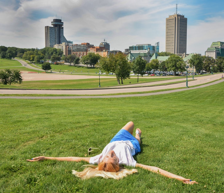 A girl lies on the grass in Parc des Champs-de-Bataille National Battlefields Park in Quebec.