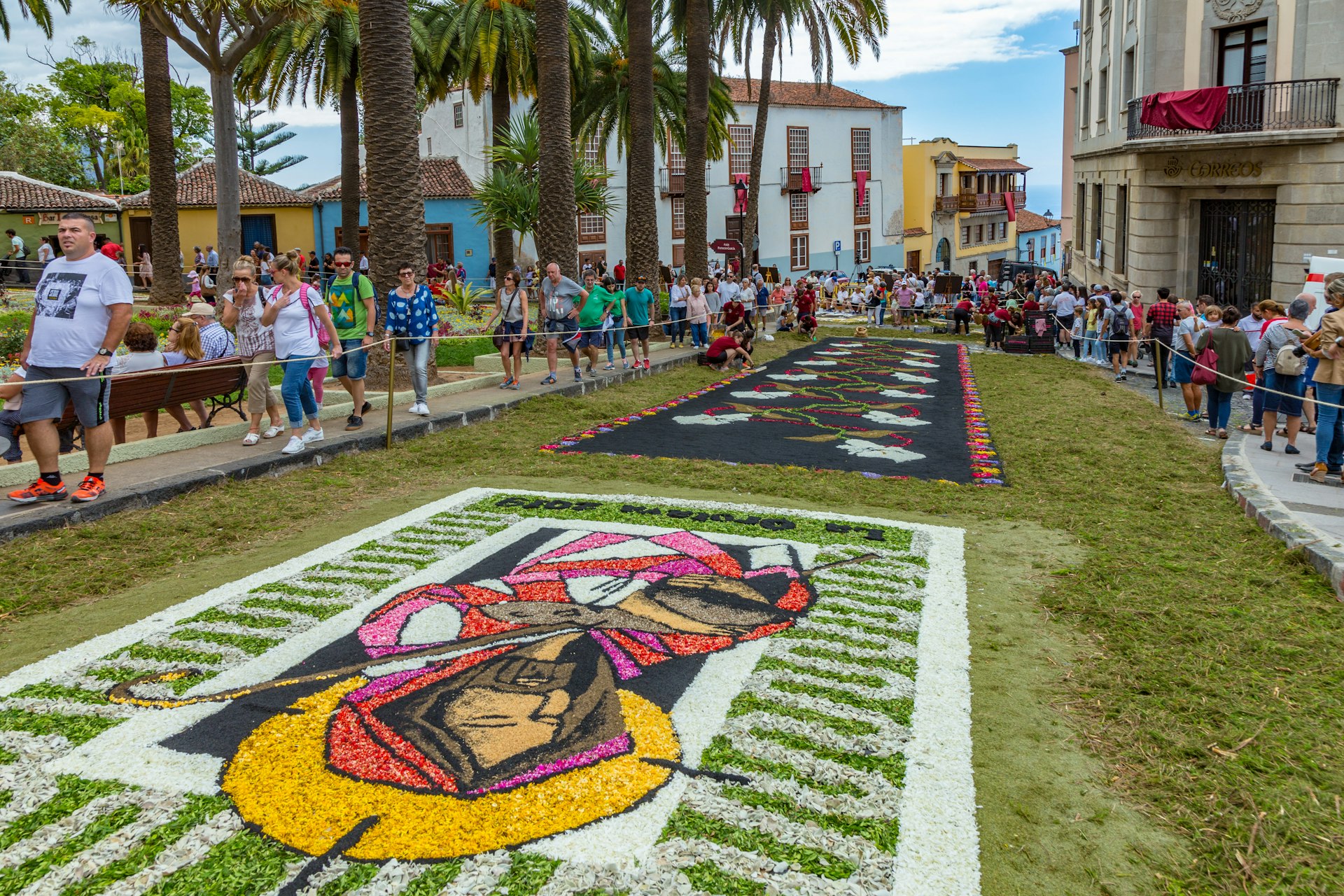People walking by and looking at flower carpets in La Orotava during Corpus Christi