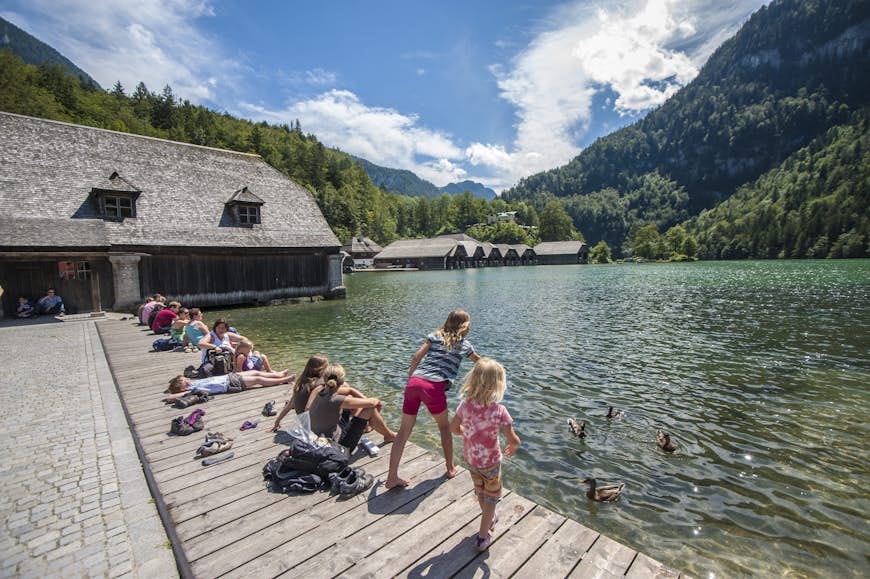 Children feeding ducks on the banks of Konigssee in the Bavarian Alps