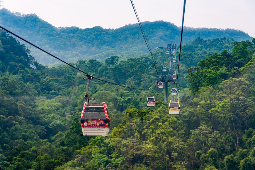 Maokong Gondola, which operates between the Taipei Zoo and Maokong, heading up a lush green hill