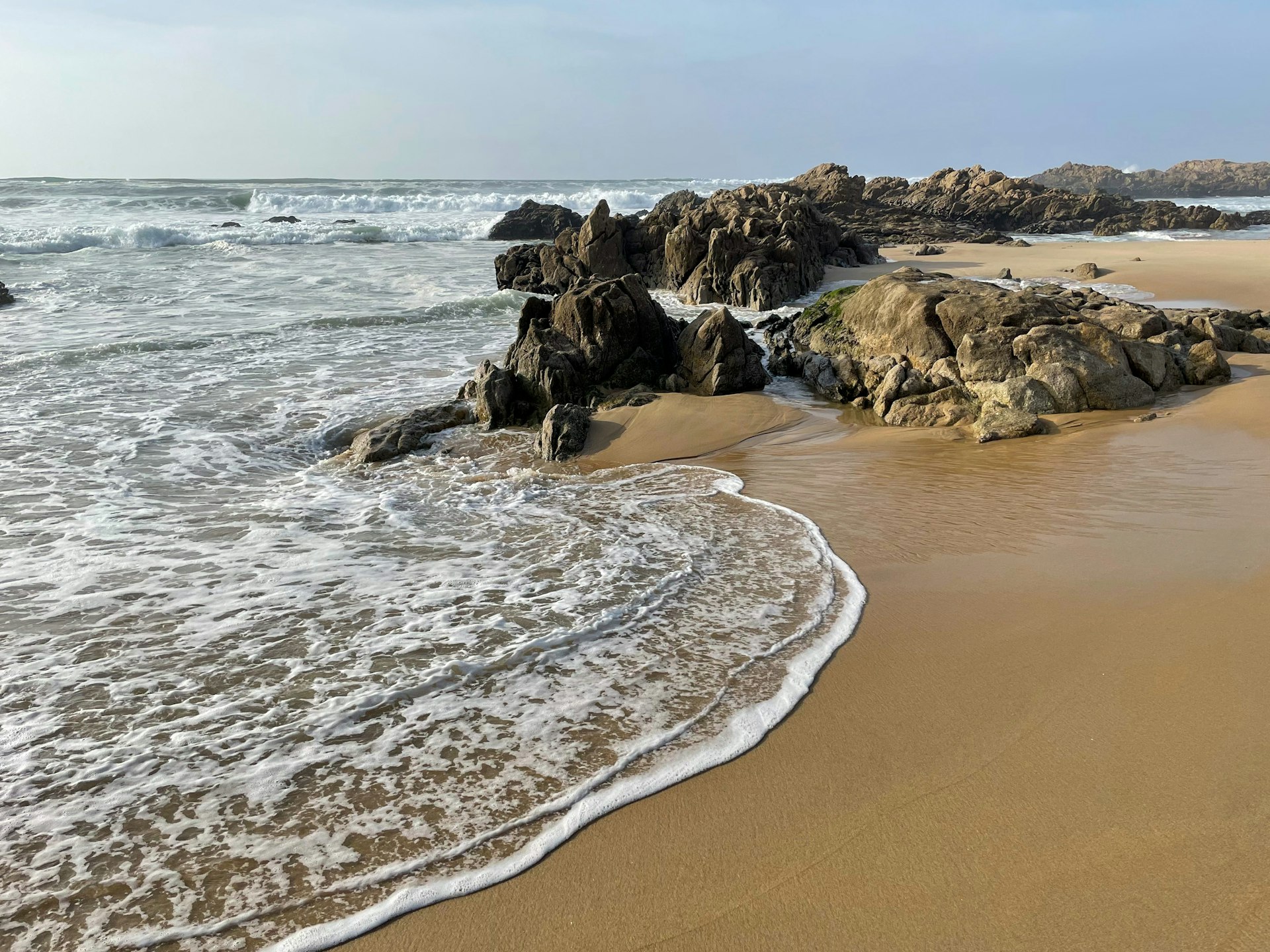 Stunning view of sandy beach with yellow rocks and Atlantic ocean in Matosinhos Beach in Portugal