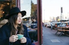 Woman with a hat taking a coffee in Fitzroy, in Melbourne. Street style.