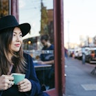 Woman with a hat taking a coffee in Fitzroy, in Melbourne. Street style.
