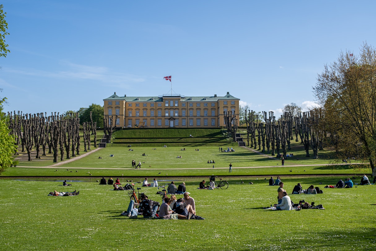 People enjoying the sunshine in front of the castle in Frederiksberg Gardens