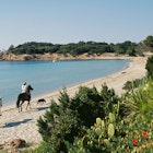 Horse riders on Palombaggia Beach near Porto Vecchio on the island of Corsica. | Location: Near Porto Vecchio, Corsica, France.