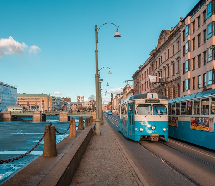 Gothenburg, Sweden - April 2, 2013: Blue old electric trams at a street by a canal, in the centre of Göteborg, important Scandinavian city of Sweden.