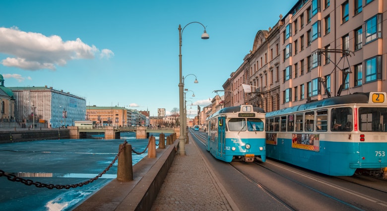 Gothenburg, Sweden - April 2, 2013: Blue old electric trams at a street by a canal, in the centre of Göteborg, important Scandinavian city of Sweden.