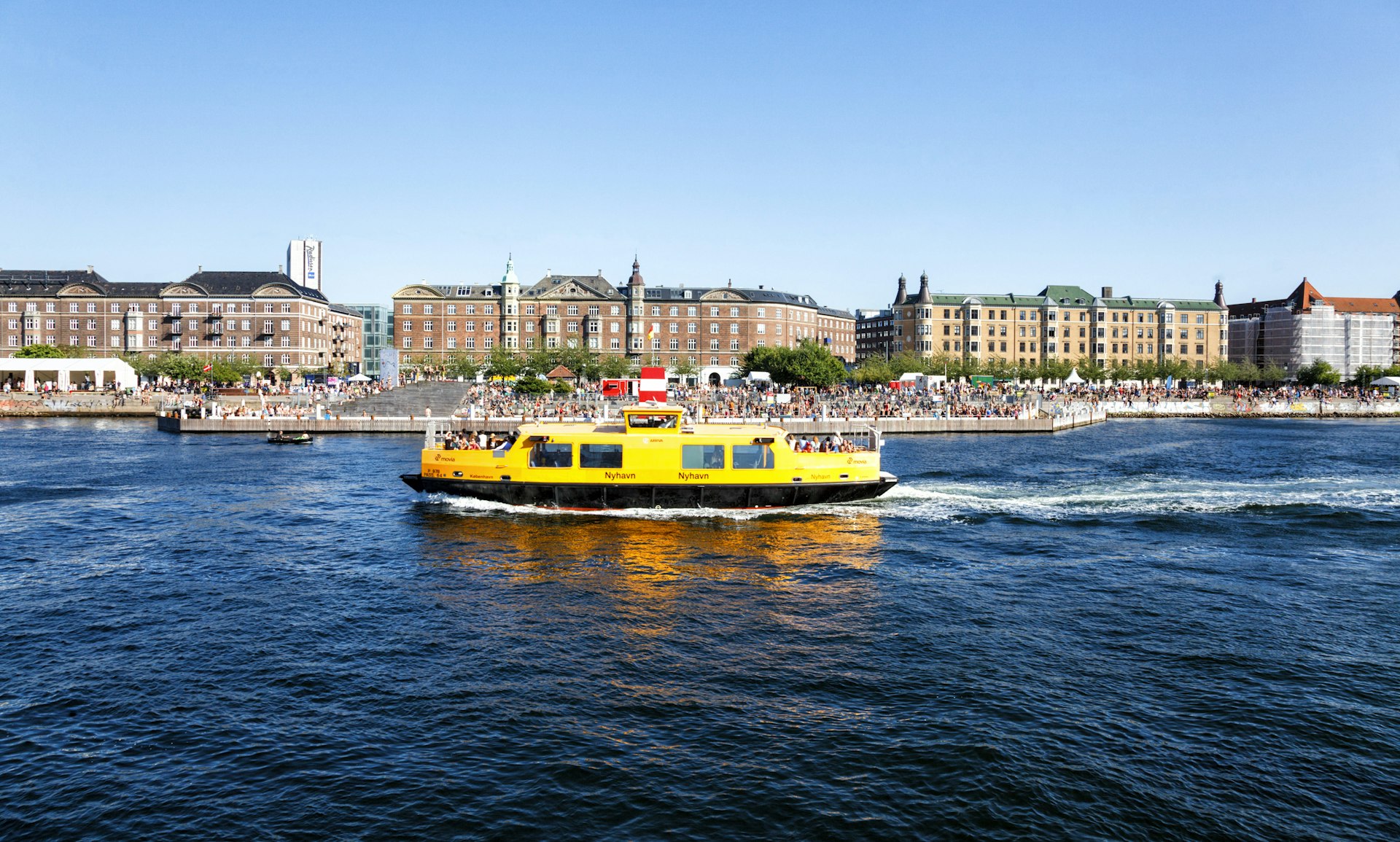 A yellow “harbor bus” passing through the harbor of Copenhagen, Denmark, Europe