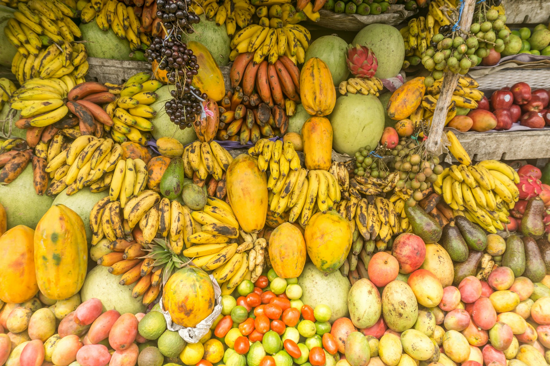 Many different colourful fruits piled together in a marketplace