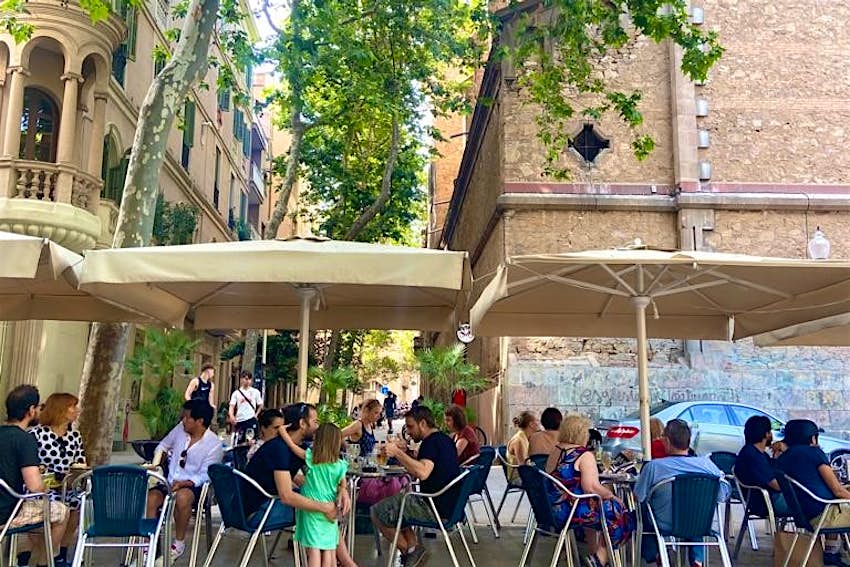 Families relax in a square in Gracia