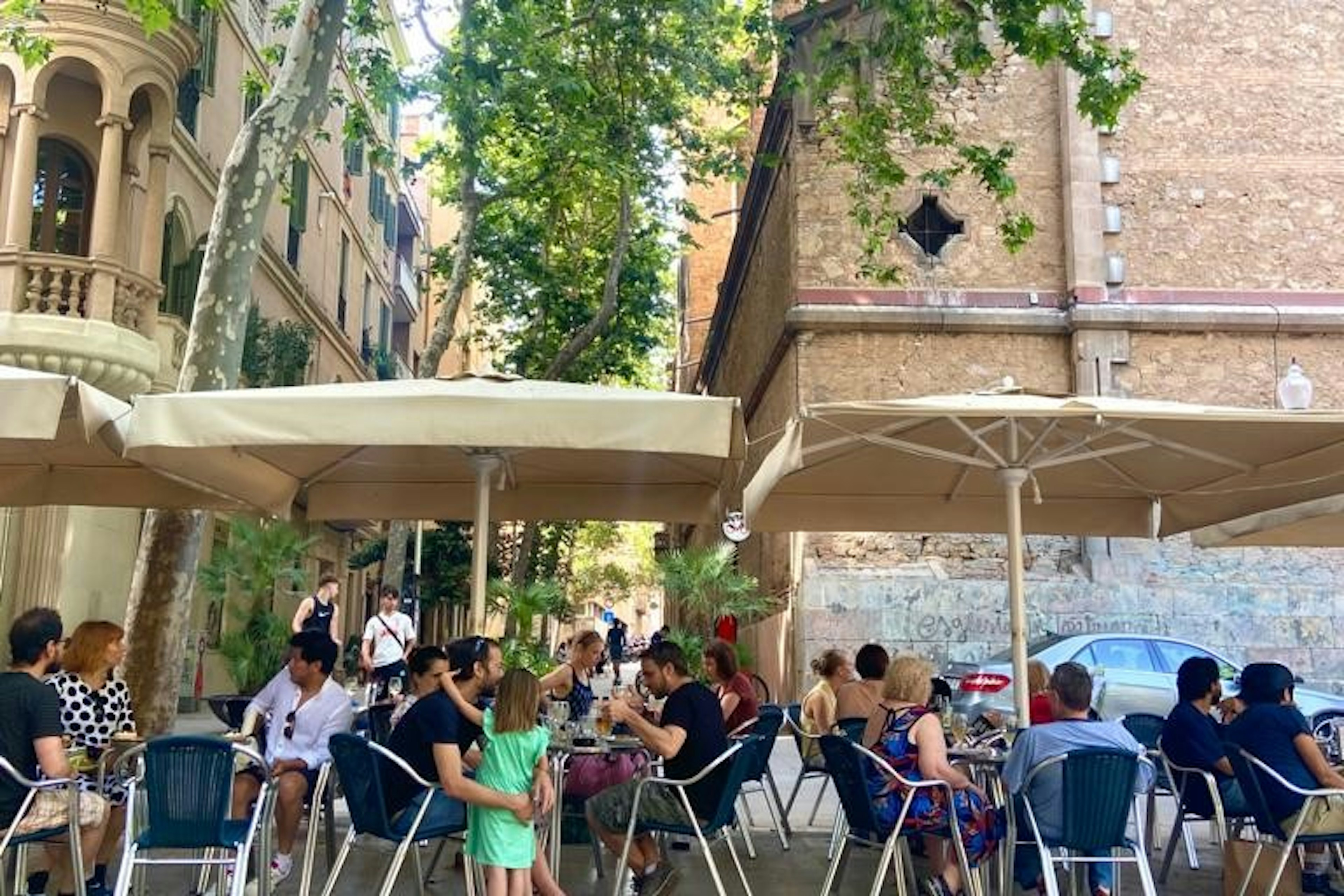 Families relax in a square in Gracia