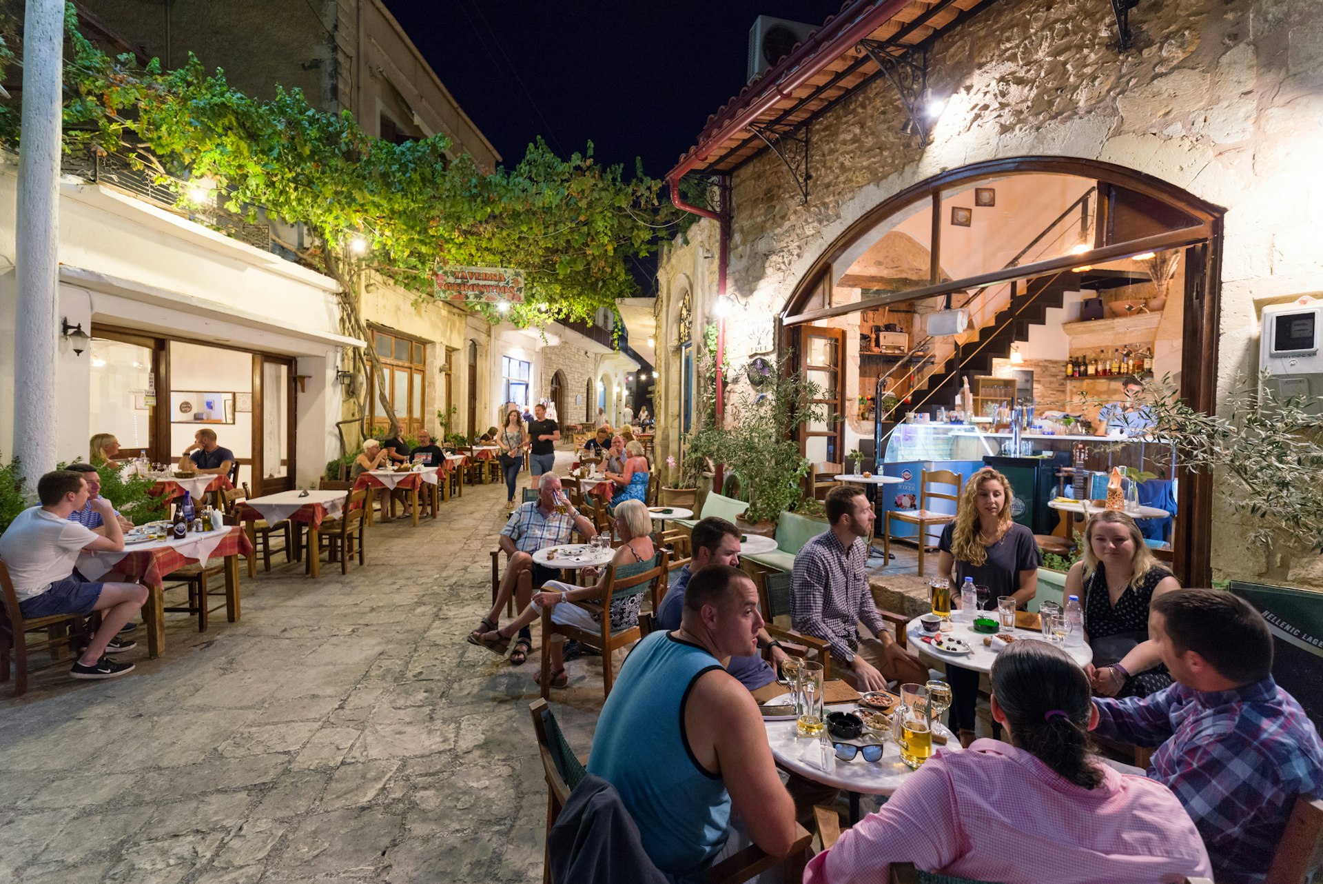 People eat outside tavernas in a village in Crete