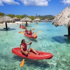 People kayaking near the beach in Roatan, Honduras