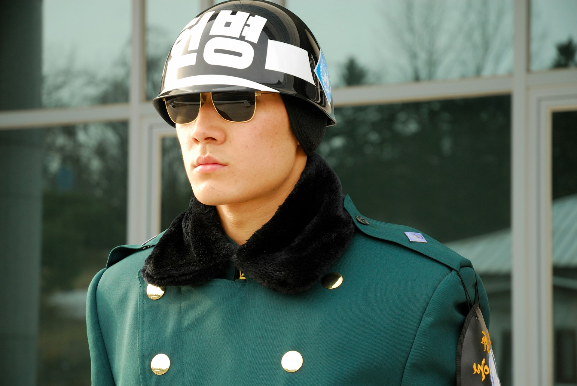A South Korean guard in sunglasses and a helmet stationed at the Demilitarized Zone (DMZ) at the border of South Korea and North Korea