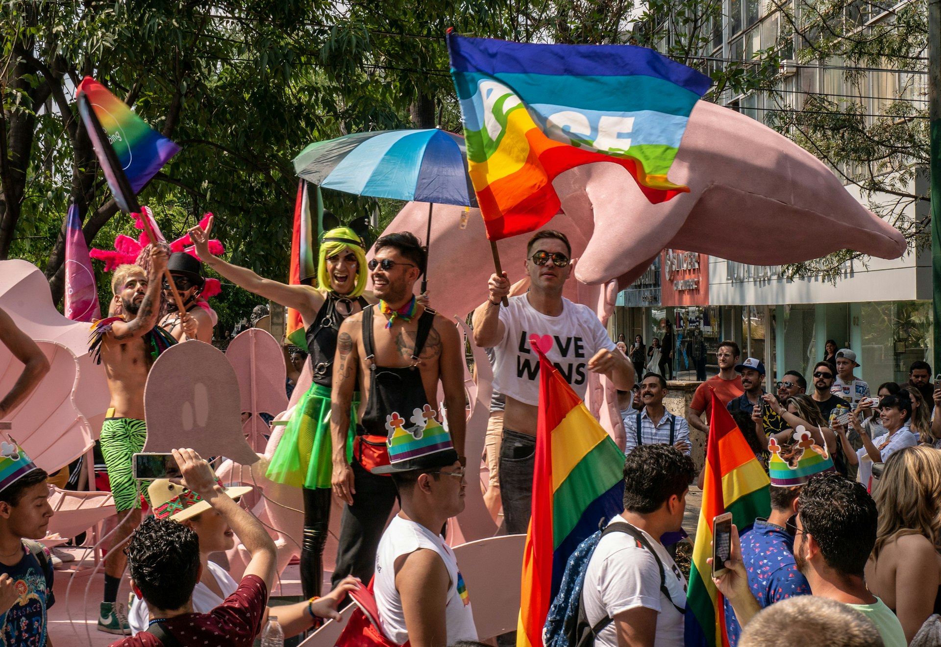 A float full of people celebrating and waving rainbow flags during the Pride Parade in Guadalajara, Jalisco, Mexico